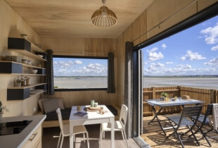 Coin salon et salle à manger de la tiny house l'indépendante avec une vue sur sa terrasse
