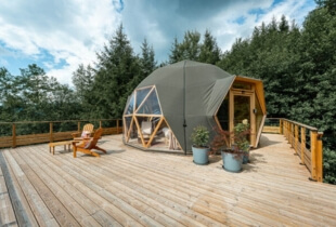Vue sur l'un des dômes géodésiques en Suisse, sur une terrasse avec des chaises longues