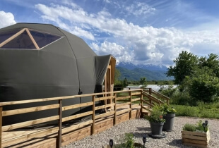 Vue sur l'un des dômes géodésiques en Suisse, sur une terrasse en bois