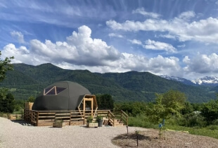 Vue sur l'un des dômes géodésiques en Suisse, avec des montagnes en arrière plan