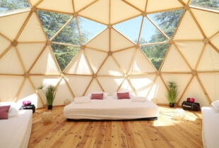 Vue de l'intérieur d'une chambre d'un dôme géodésique de 5m avec une partie de la toile transparente qui permet de voir le ciel