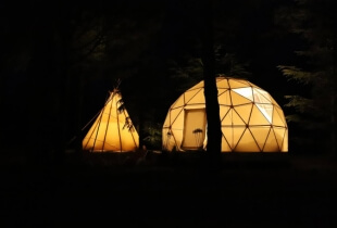 Vue de l'extérieur d'un dôme géodésique éclairé en pleine nuit