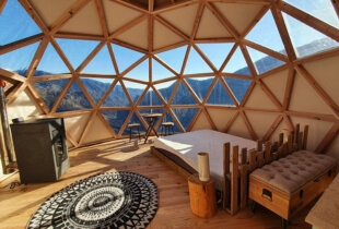 Vue de l'intérieur d'une chambre d'un dôme géodésique de 5m avec une partie de la toile transparente qui permet de voir l'extérieur