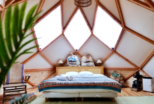 Vue de l'intérieur d'une chambre d'un dôme géodésique Zome avec une partie de la toile transparente qui permet de voir le ciel
