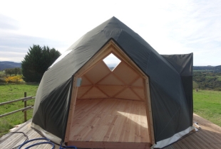 Vue sur l'intérieur d'un dôme géodésique Zome, installé sur une terrasse en bois