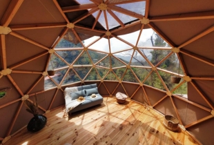 Vue de l'intérieur d'une chambre d'un dôme géodésique de 6m avec une partie de la toile transparente qui permet de voir l'extérieur