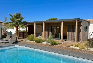 Un studio de jardin en suisse installé devant une grande piscine privée