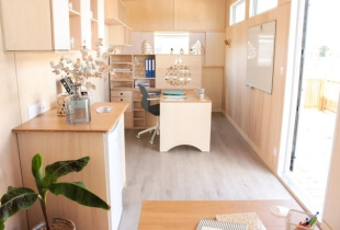 Vue sur l'un des bureaux en bois clair de la tiny house proposant des bureaux indépendants