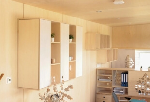 Meubles de rangements en bois clair de la tiny house proposant des bureaux indépendants