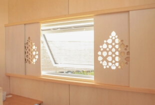 Fenêtre avec volet en bois de la tiny house proposant des bureaux indépendants