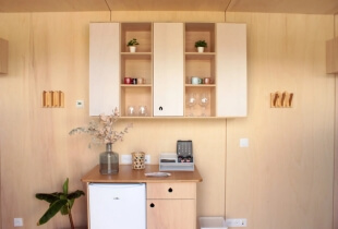 Coin avec meubles de rangements en bois clair de la tiny house proposant des bureaux indépendants