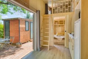 Vue sur la terrasse de la tiny house l'intrépide, depuis l'intérieur